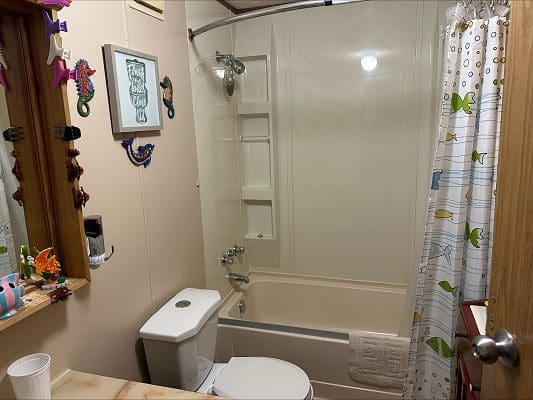 Bathroom with tub, toilet, and shower.