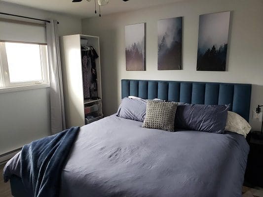 Blue bedroom with forest print art.