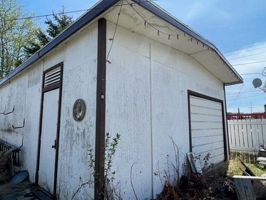 White weathered garage with door.