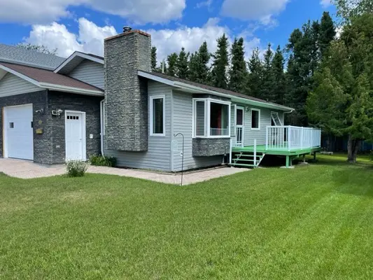 A home with a garage and grass in front of it.