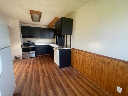 Kitchen with dark cabinets and wood flooring.