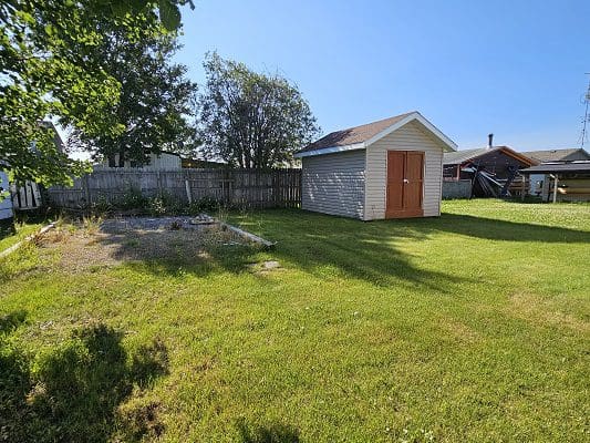Yard with shed and wooden fence.