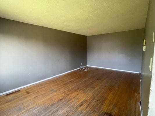 Empty room with hardwood floors.