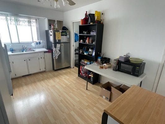 Kitchen with appliances and light wood floors.