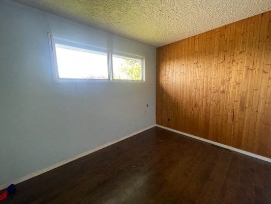 Empty bedroom with wood paneling.