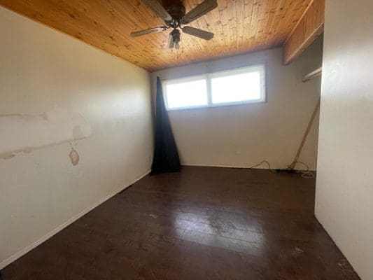 Empty room with wood floor and ceiling fan.