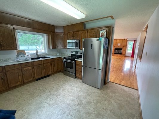 A kitchen with wood cabinets and stainless steel appliances.