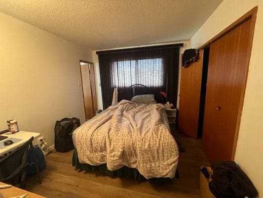 Bedroom with unmade bed and closet.