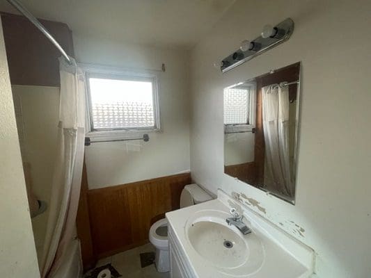 Small bathroom with shower and sink.