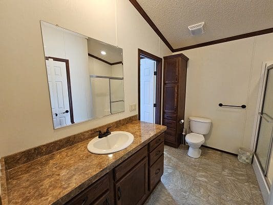 Bathroom with vanity, sink, and toilet.