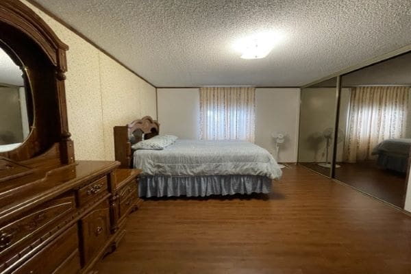 Bedroom with dresser and queen bed.