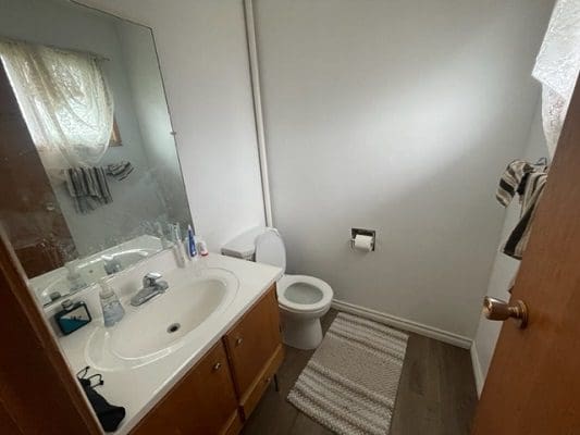Bathroom with sink, toilet, and mirror.