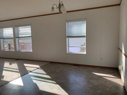 Sunny empty room with three windows.