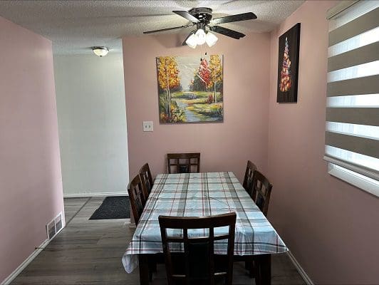 Dining room with plaid tablecloth and autumn art.