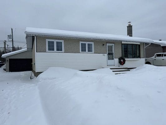 Snow-covered house with attached garage.