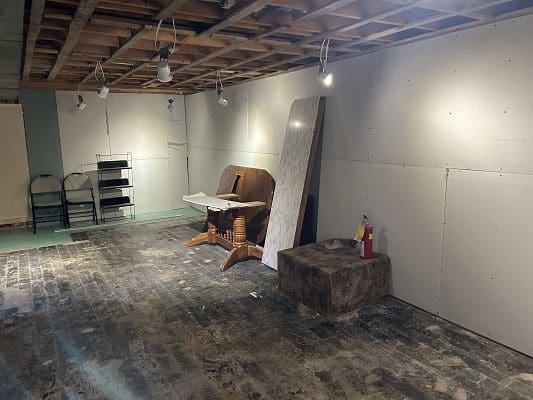 Unfinished basement with old furniture.