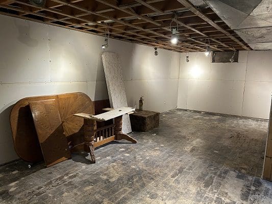 Unfinished basement with old furniture.