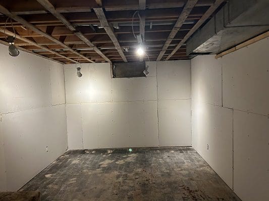 Unfinished basement with drywall installed.