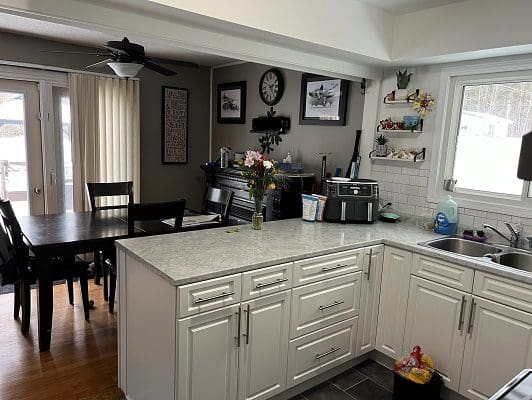 Kitchen with island, dining area, and white cabinets.