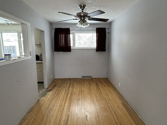 Empty dining room with hardwood floors.
