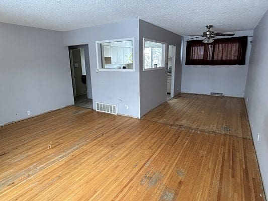 Empty living room with hardwood floors.