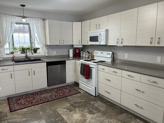White kitchen with stainless steel appliances.