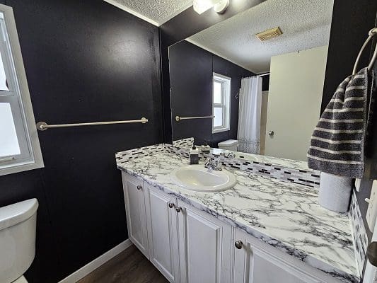 White marble bathroom vanity with sink.