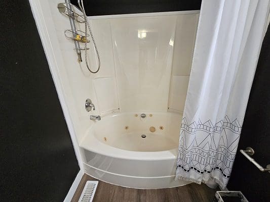 White bathtub with shower and curtain.