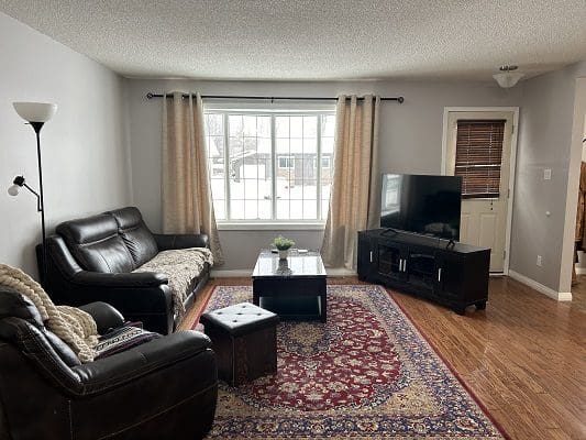 Living room with leather furniture and TV.