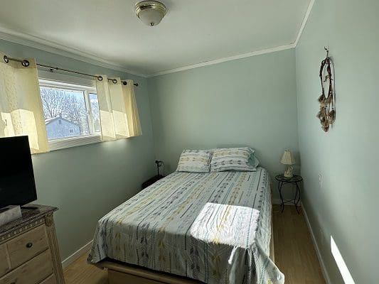 Bedroom with bed, window, and dreamcatcher.