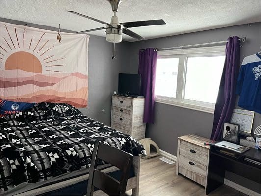 Bedroom with bed, dresser, and window.