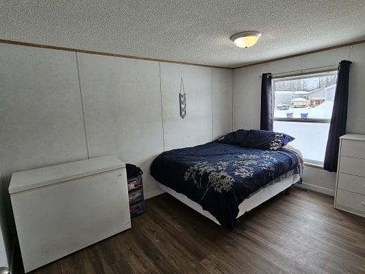 Bedroom with bed, window, and dresser.