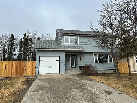 Gray house with attached garage and fence.