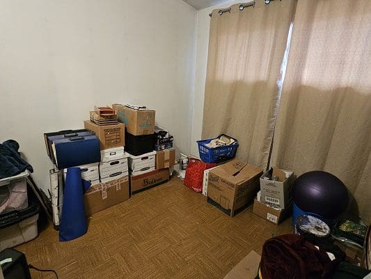 Packed boxes and belongings in a room.