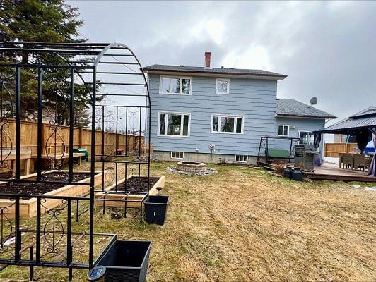 Backyard garden with raised beds and house.