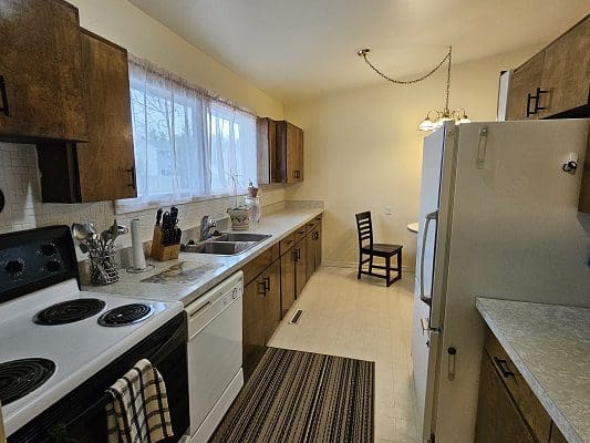 Kitchen with wooden cabinets and appliances.
