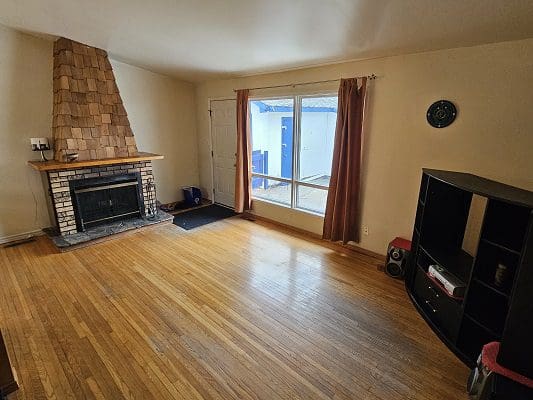 Living room with fireplace and hardwood floors.