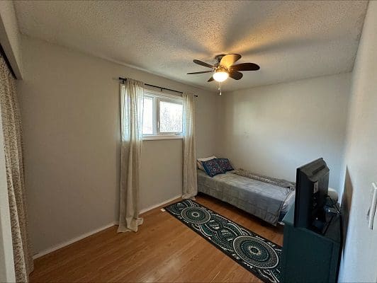 Small bedroom with twin bed and TV.