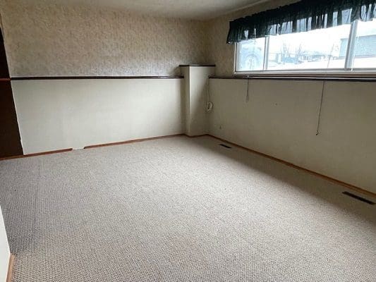 Empty carpeted room with window.