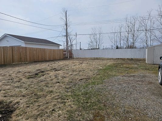 Empty lot with house and fences.