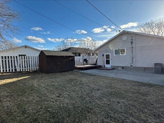 House backyard with shed and fence.
