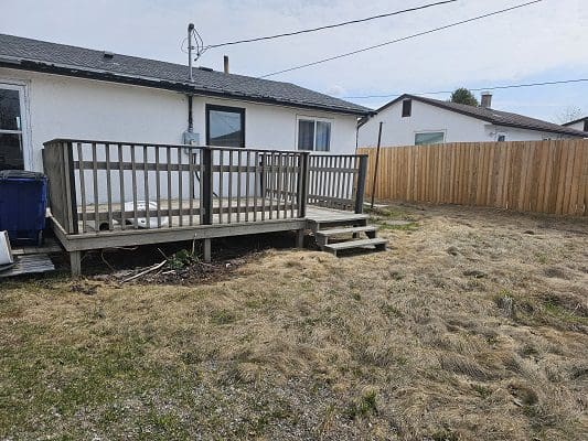 House with wooden deck and fence.