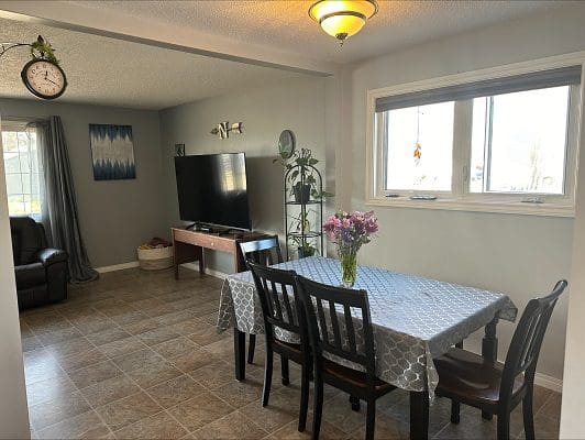 Dining room with TV and tiled floor.