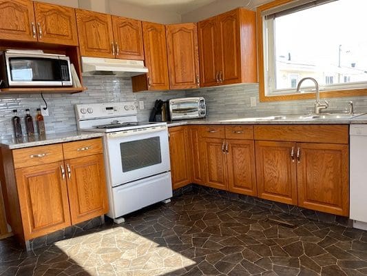 Oak kitchen with white appliances.