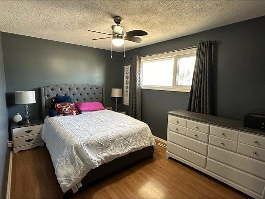 Bedroom with bed, dresser, and window.