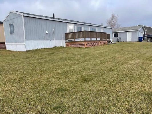 Mobile home with deck and yard.