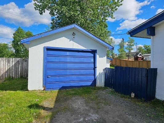 Detached garage with blue door.