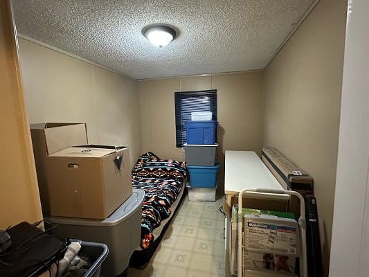 Small bedroom with bed and boxes.