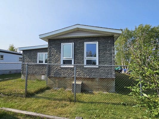 Stone house with windows and fence.