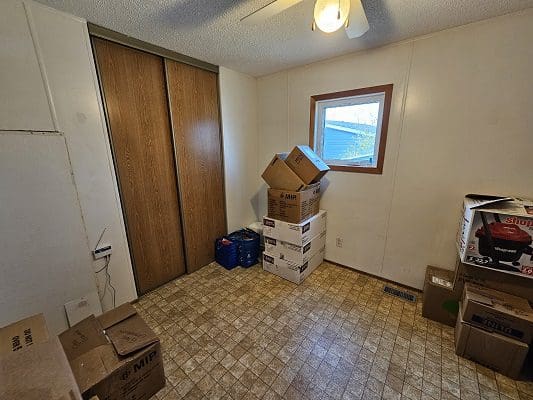 Spare bedroom with boxes and closet.